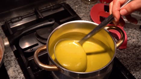 stirring pot of soup on stove