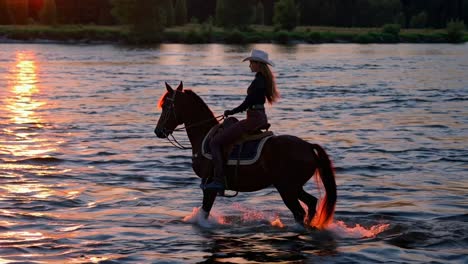 woman riding horse in a river at sunset