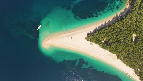 Eine-Vogelperspektive-Zeigt-Boote,-Die-Am-Strand-Von-Zlatni-Rat-Auf-Der-Insel-Brac,-Kroatien,-Verankert-Sind