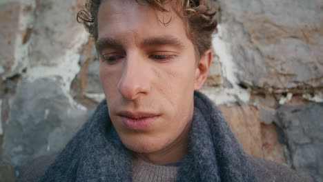 pensive guy pondering alone at old building background closeup. man thinking