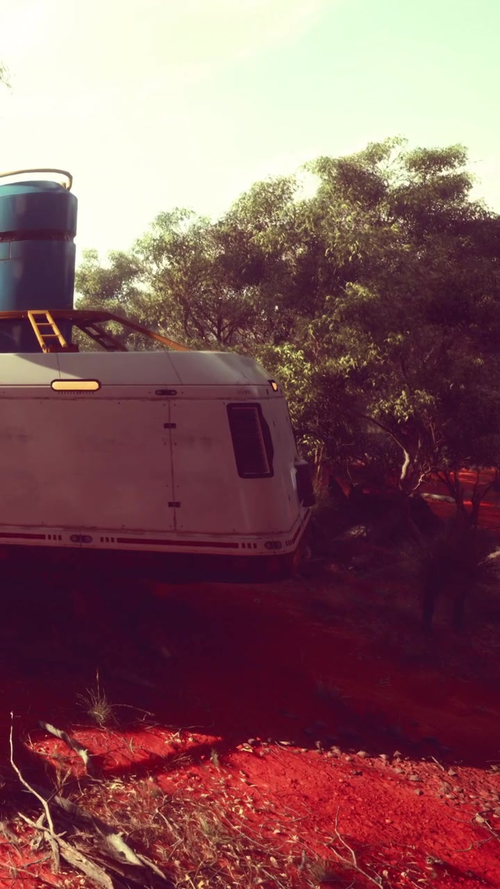 Caravan parcheggiato su una strada sterrata rossa circondata da alberi nel deserto.