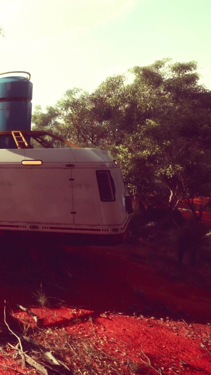 Caravan parcheggiato su una strada sterrata rossa circondata da alberi nel deserto.