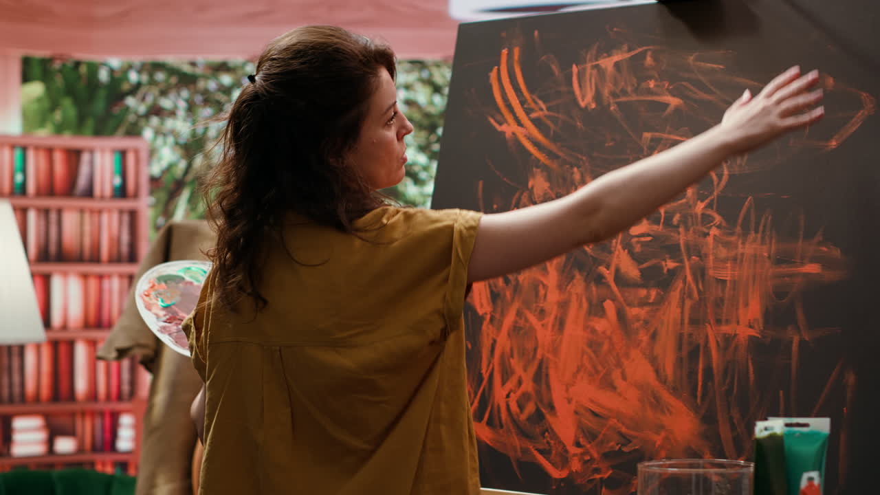 Woman painting abstract art on canvas