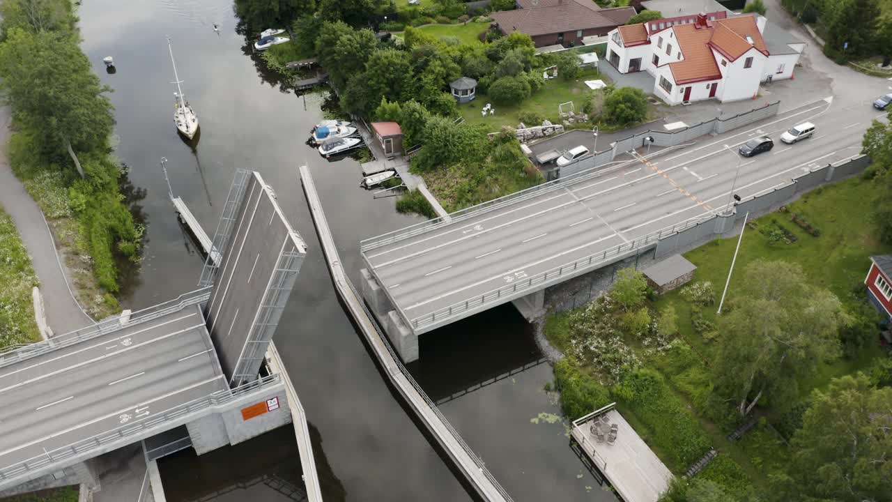 Aerial of bridge opening while sailboat and cars wait to pass