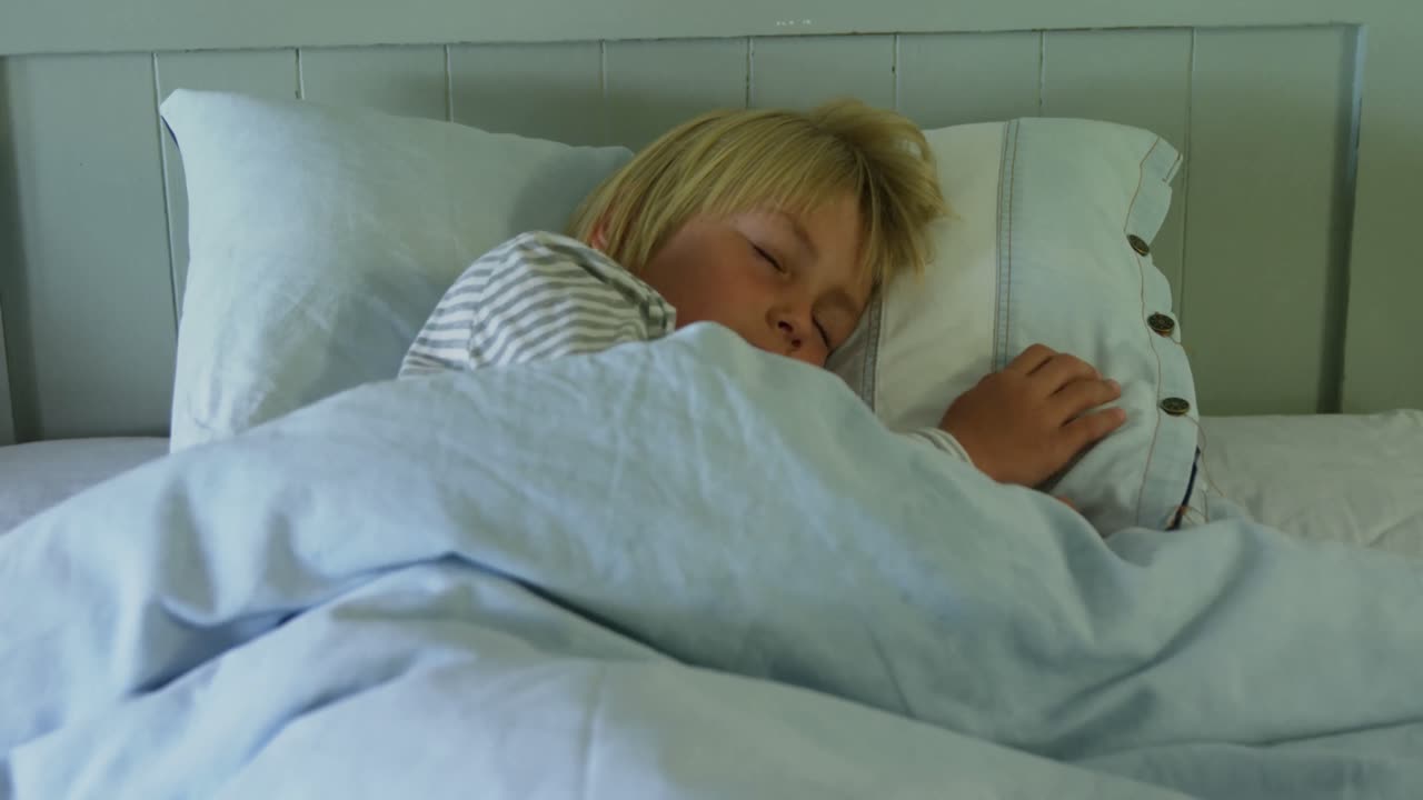 niño durmiendo en la cama en el dormitorio 4k