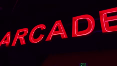 a red neon sign that reads "arcade" on a black background