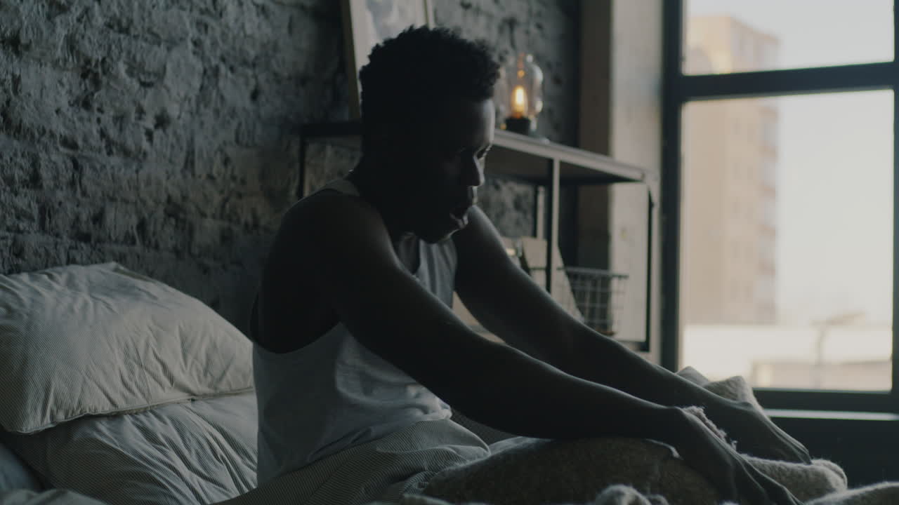 Uomo che dorme e si sveglia in camera da letto