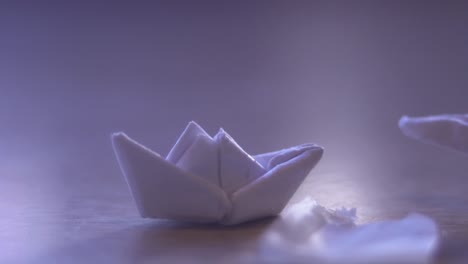 playing with miniature paper boat