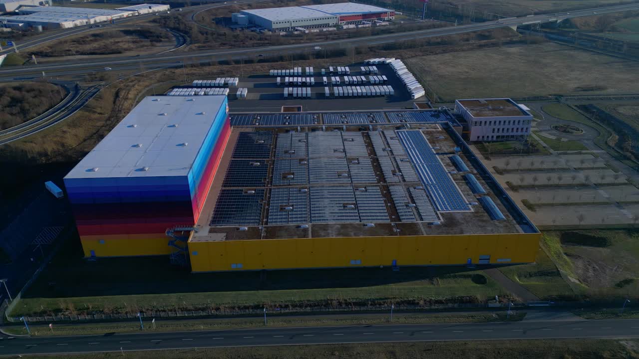 Panorama di un centro logistico e di un magazzino di distribuzione al servizio della catena di drugstore, situato accanto a un canale e all'infrastruttura autostradale. Splendida ripresa aerea con drone dall'alto