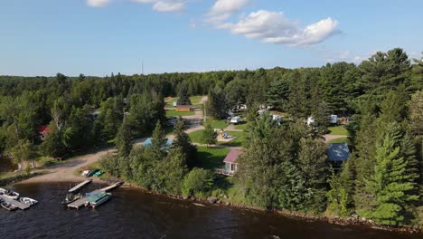 establishing drone shot of a trailer park surrounded by a stunning forest in rural canada