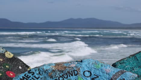 las olas chocan contra las coloridas rocas de la orilla