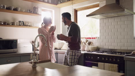 a couple enjoying coffee in their kitchen at home