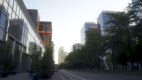 brussels nord urban setting with high glass business buildings, during sunrise in the summer with a car coming in the distance. close to the brussels north train station.