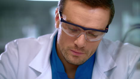 scientist corrects glasses. portrait of scientist focused on work