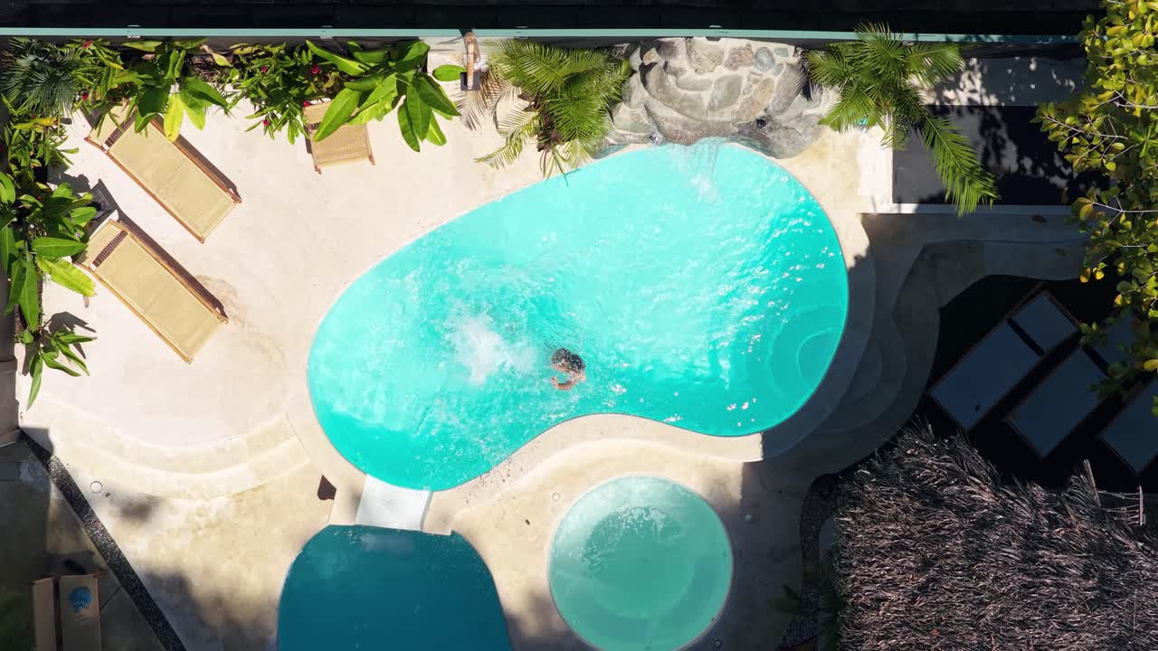 Luftfoto af et par, der svømmer og slapper af i en luksusresortpool