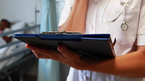 female doctor writing on a clipboard