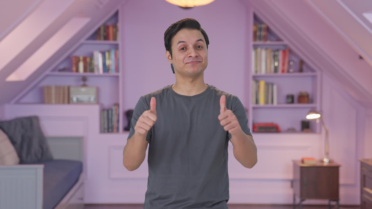 Uomo indiano felice che mostra il pollice in su