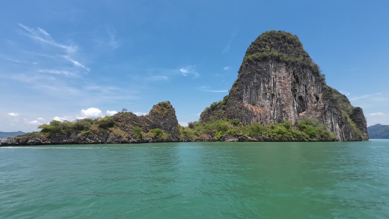 Một chuyến đi thuyền ngắm cảnh qua những vách đá vôi cao chót vót ở Vịnh Phang Nga, Phuket, Thái Lan, với làn nước nhiệt đới, các khối đá karst hùng vĩ và là một điểm đến du lịch nổi tiếng