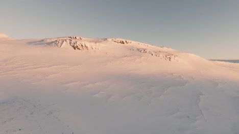 View-at-snowy-mountains-and-ocean-shore,-at-sunset