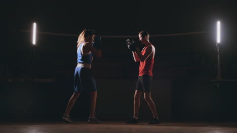 fitness woman athlete boxing punching focus mitts enjoying intense exercise female fighter training friend in gym workout together slow motion