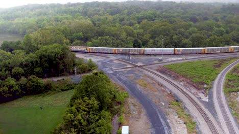 toma aérea de un tren en montañas nubladas