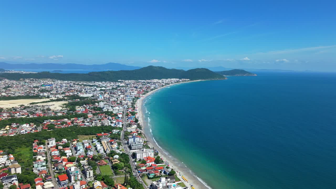 Vista aerea della spiaggia costiera e popolare di Praia Dos Ingleses con l'Oceano Atlantico turchese, Florianopolis, Santa Catarina, Brasile