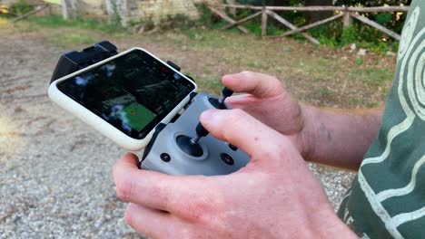 a boy remotely controls a drone, detail of hands in an open space