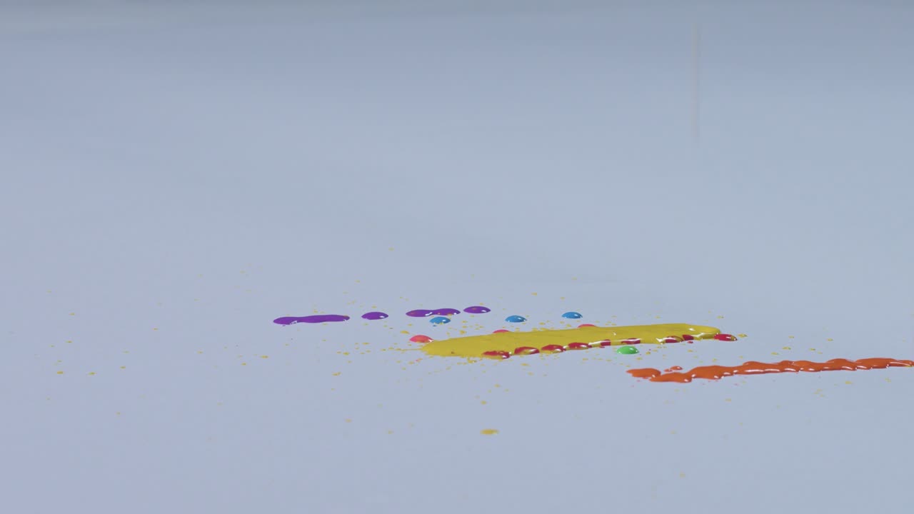 varios colores están goteando sobre un fondo blanco.