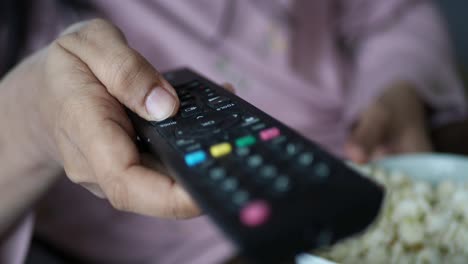 persona viendo televisión y comiendo palomitas de maíz