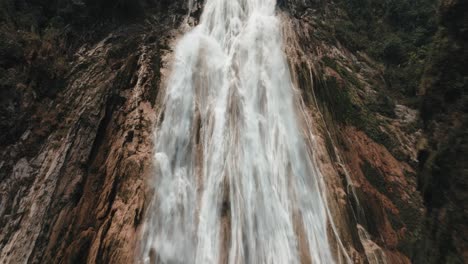 tourists seeing the magnificent waterfalls of chiflon as descends over the rocky cliff in chiapas, mexico