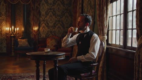 a man drinks tea in an elegant, historical room
