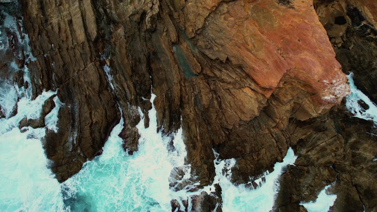 un dron de olas de color azul claro choca contra las rocas de la piscina azul de bermagui, australia 2