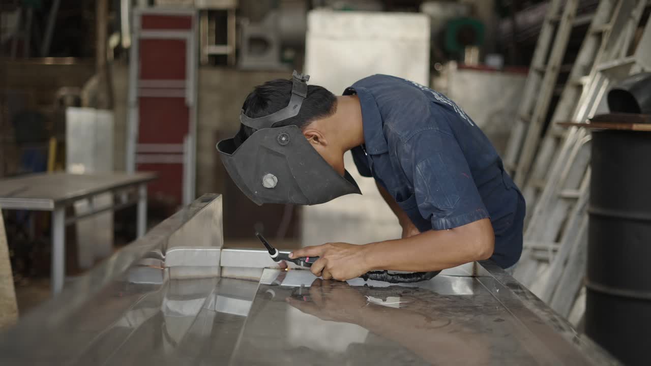 A welder performing metalwork in a workshop
