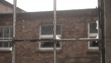 Abandoned-old-building,-rain-falling-through-old-broken-window-panes