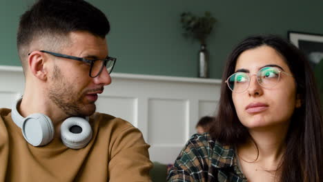 bottom view of a student with headphones talking with female mate at table discussing about a project