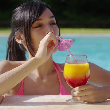 happy smiling young woman with a fruity cocktail