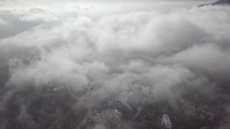 gliding above the clouds looking down on a snowy mountain range
