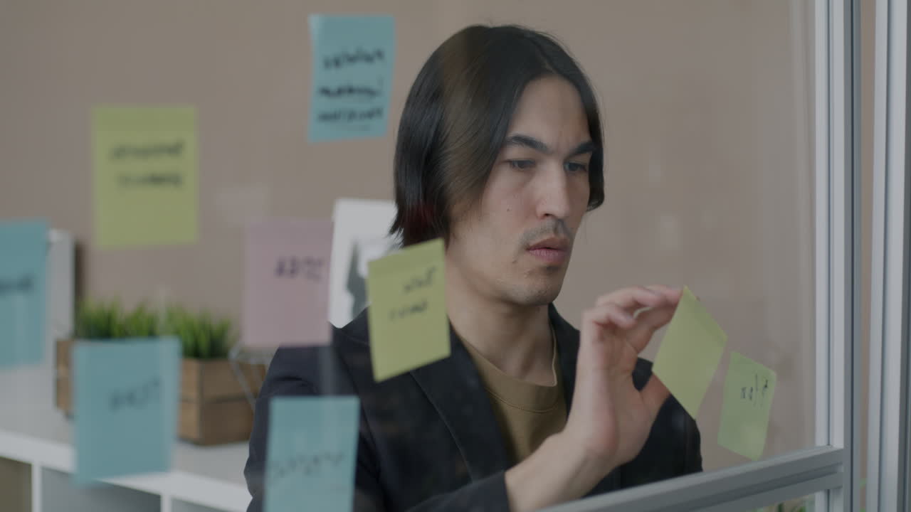 Man Brainstorming with Sticky Notes