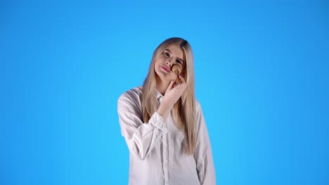 cute caucasian woman applies makeup with cosmetic brush, looking at camera