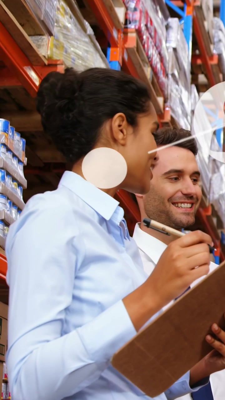 Video verticale: Un magazziniere controlla un blocco appunti mentre un collega indica, con icone di rete sovrapposte al magazzino.