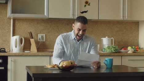 man celebrating good news in kitchen
