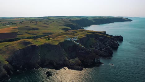 discover scotland’s coast: aerial perspectives of rocky shoreline of st abbs head and lighthouse on british coast in remote scottish borders