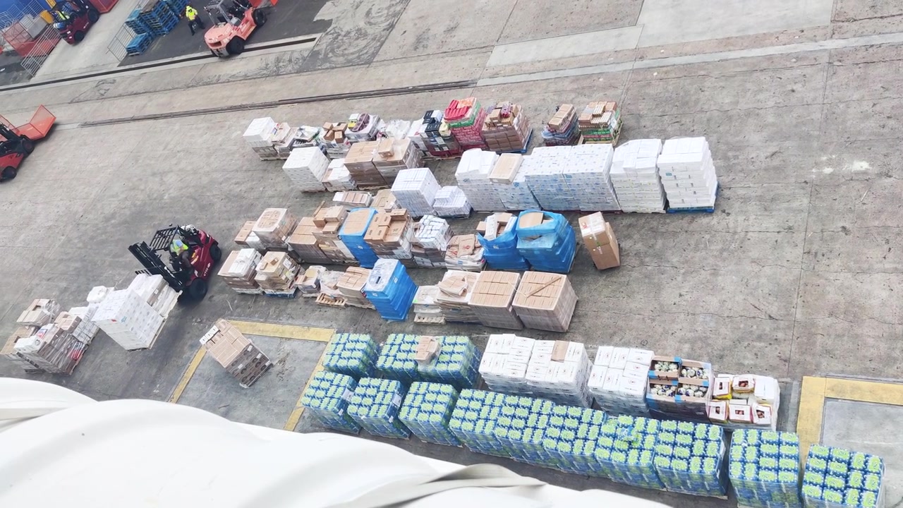 In the bustling port of Miami, a cruise ship diligently prepares for its voyage, as the crew works tirelessly to fill food and water supplies , food supplies, amenities, boxes, cruise ship