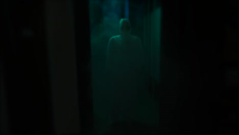 mysterious figure in a hazmat suit in a dark corridor