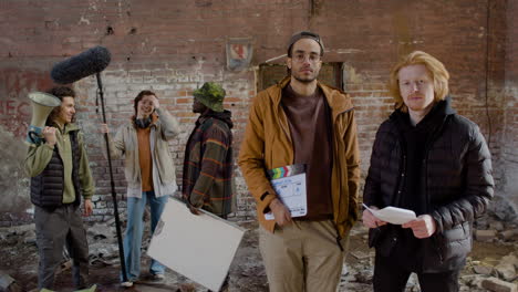 dos compañeros de producción mirando la cámara en un edificio en ruinas 1