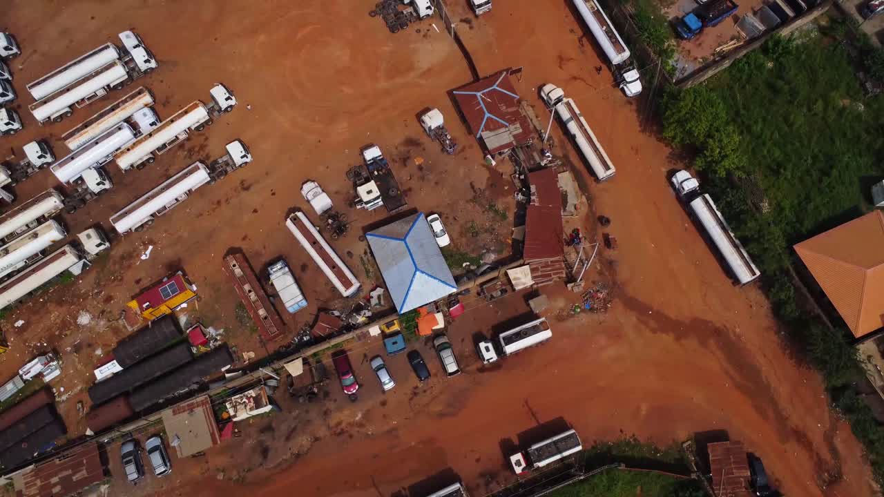 Top down aerial of fuel trucks parked on a industrial site in Ibadan, Nigeria on a sunny day