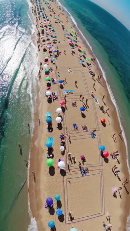 aerial view of a crowded beach with colorful umbrellas and people