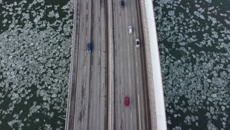 Rare-iceberg-circular-fungi-algae-bubbles-headed-west-down-the-North-Saskatchewan-River-while-drone-flys-south-over-the-vantage-classic-Quesnel-bridge-with-light-traffic-in-Edmonton-Alberta-Canada-3-3