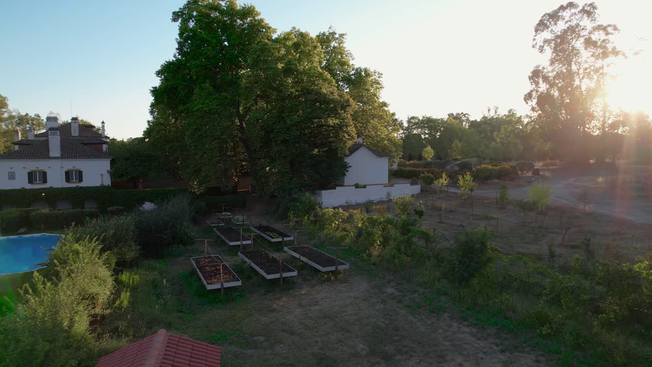 La luz del amanecer en la hora dorada ilumina los parterres elevados en una casa de campo rural.