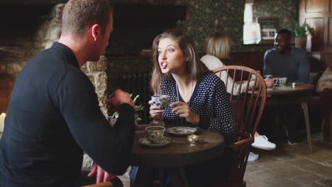 couple sitting at table drinking tea in traditional english holiday hotel